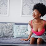 attractive african american woman with afro hair wear skirt pink top posed white room fashionable sexy black model 1.jpg