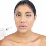 unsmiling nude brunette holding injection looking camera.jpg