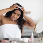 upset young african american woman checking her hair scaled 1.jpg